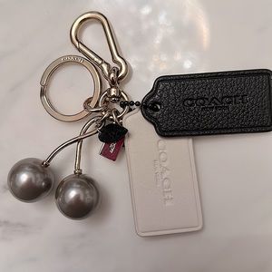 Coach cherry bag charm with black and white leather tags